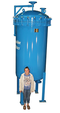 Large blue horizontal plate filter with a clamped lid, shown with a person standing beside it for size reference.